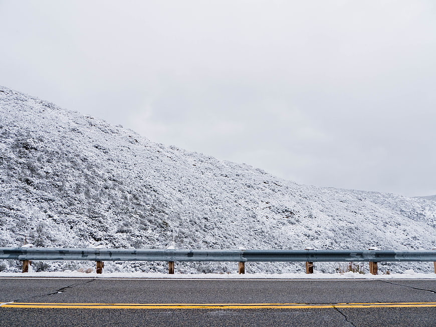 Winter Highway Roadside with Snowy Mountain Background