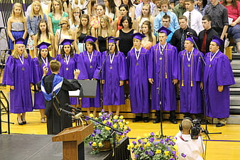 High School Choir Singing in Purple Gowns at Graduation Ceremony