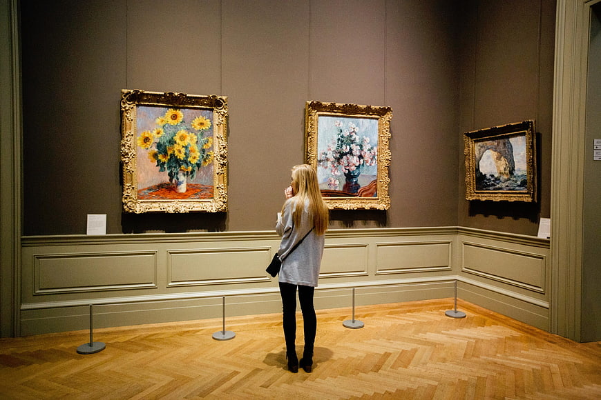 Woman Viewing Van Gogh Sunflowers in Museum Gallery