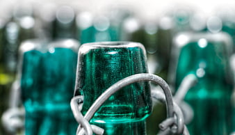 Close-up of vintage green glass bottles with wire closures