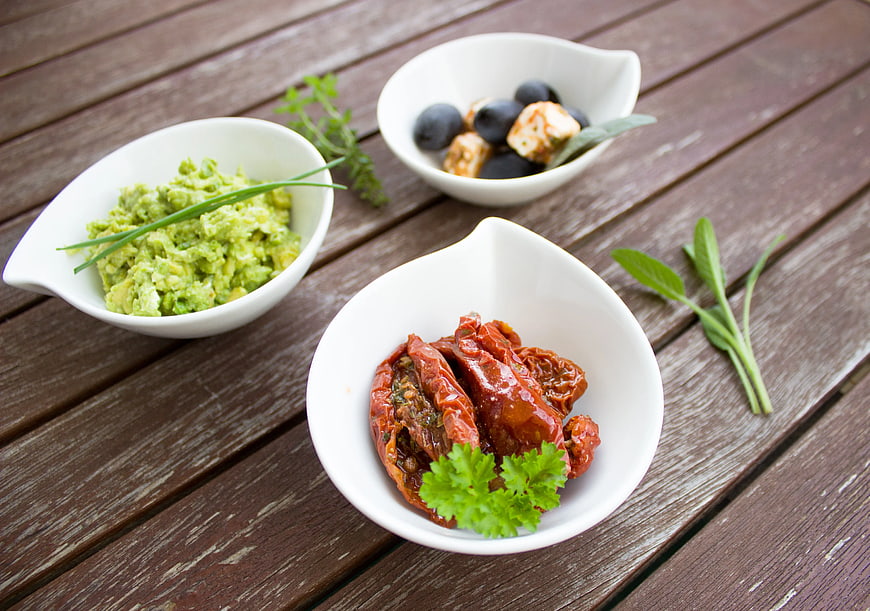 Mediterranean appetizers with guacamole, olives, and sun-dried tomatoes