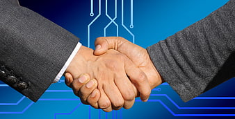Business handshake over blue digital circuit board background