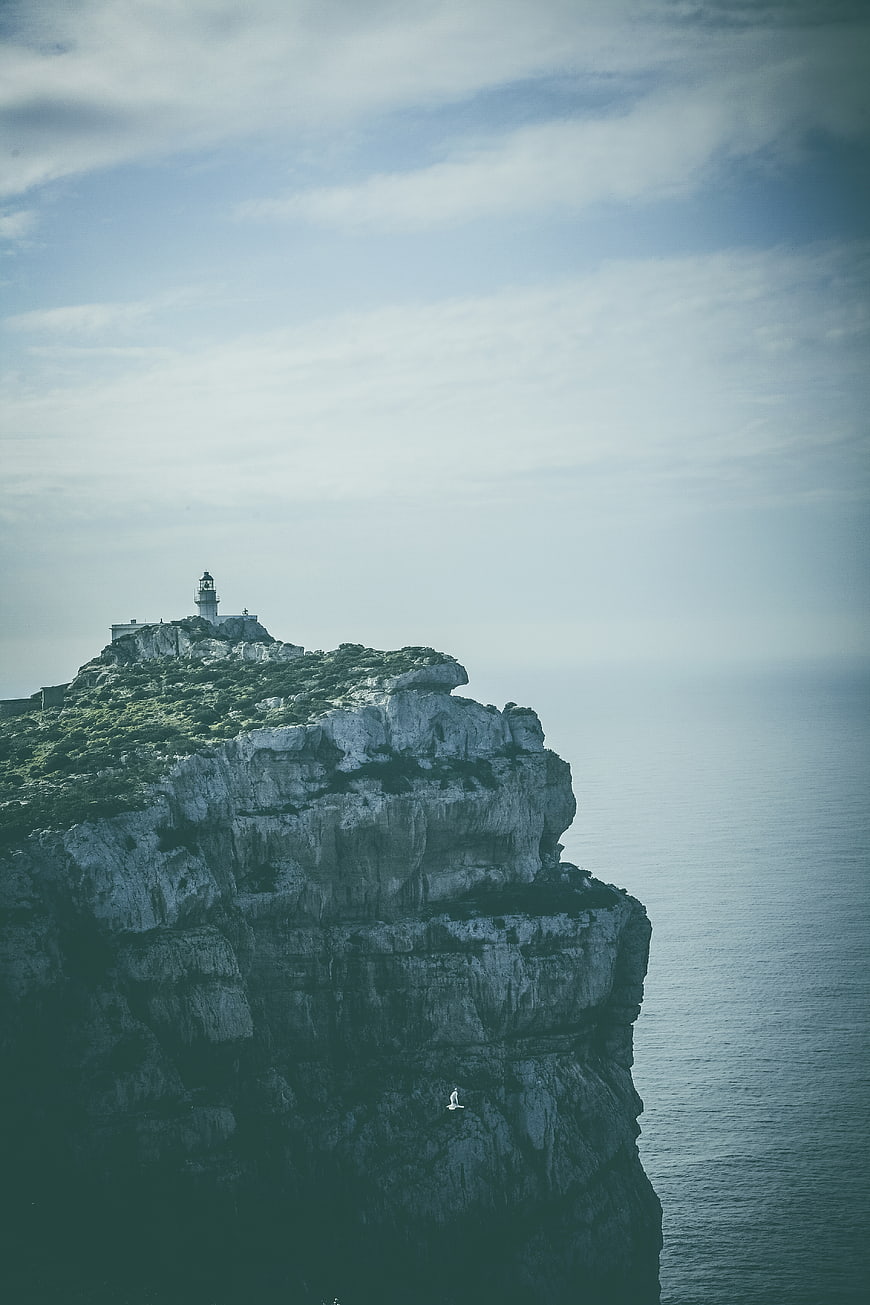 Lighthouse on Rocky Cliff Overlooking Ocean