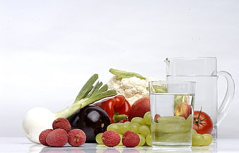 Fresh Fruits, Vegetables, and Water Pitcher on White Background