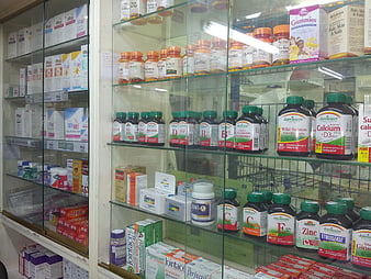 Glass display cabinet filled with vitamins and health supplements