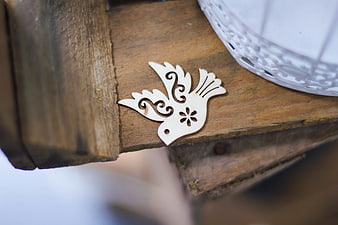 Laser-cut wooden bird ornament on rustic wood