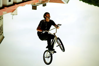 BMX Rider Performing Mid-Air Trick Against Sky