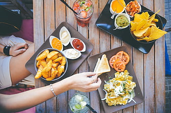 Overhead view of breakfast platters and drinks on wooden table