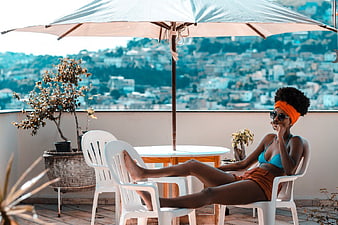 Relaxed Woman in Bikini on Balcony with City View