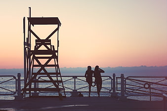 Silhouette of Two Women on Pier at Sunset