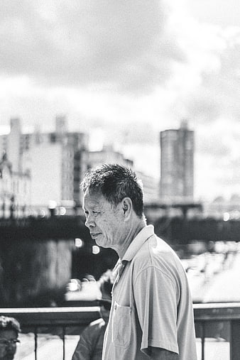 Black and white portrait of elderly Asian man in city
