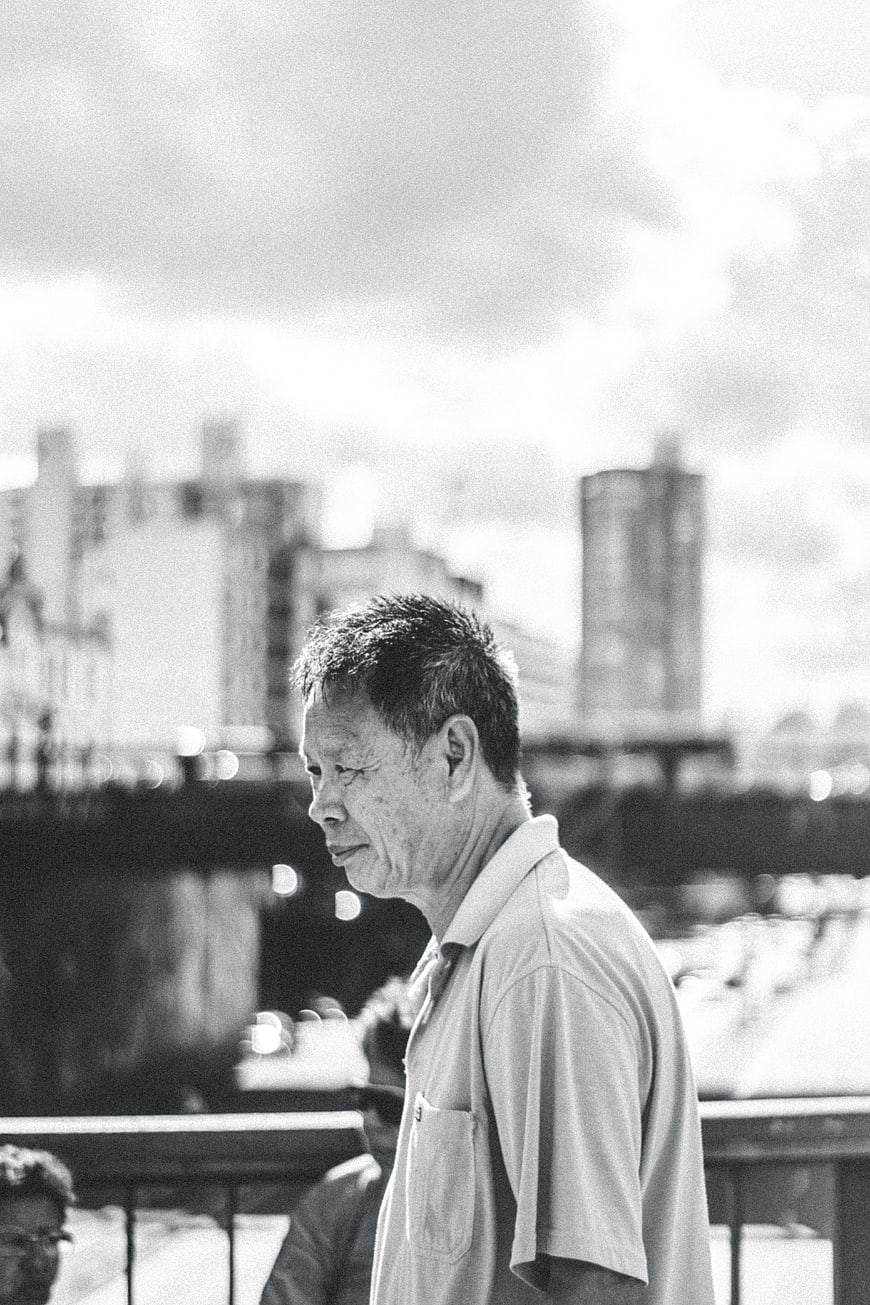 Black and white portrait of elderly Asian man in city