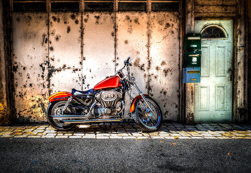 Red Custom Chopper Motorcycle Parked Against Weathered Wall