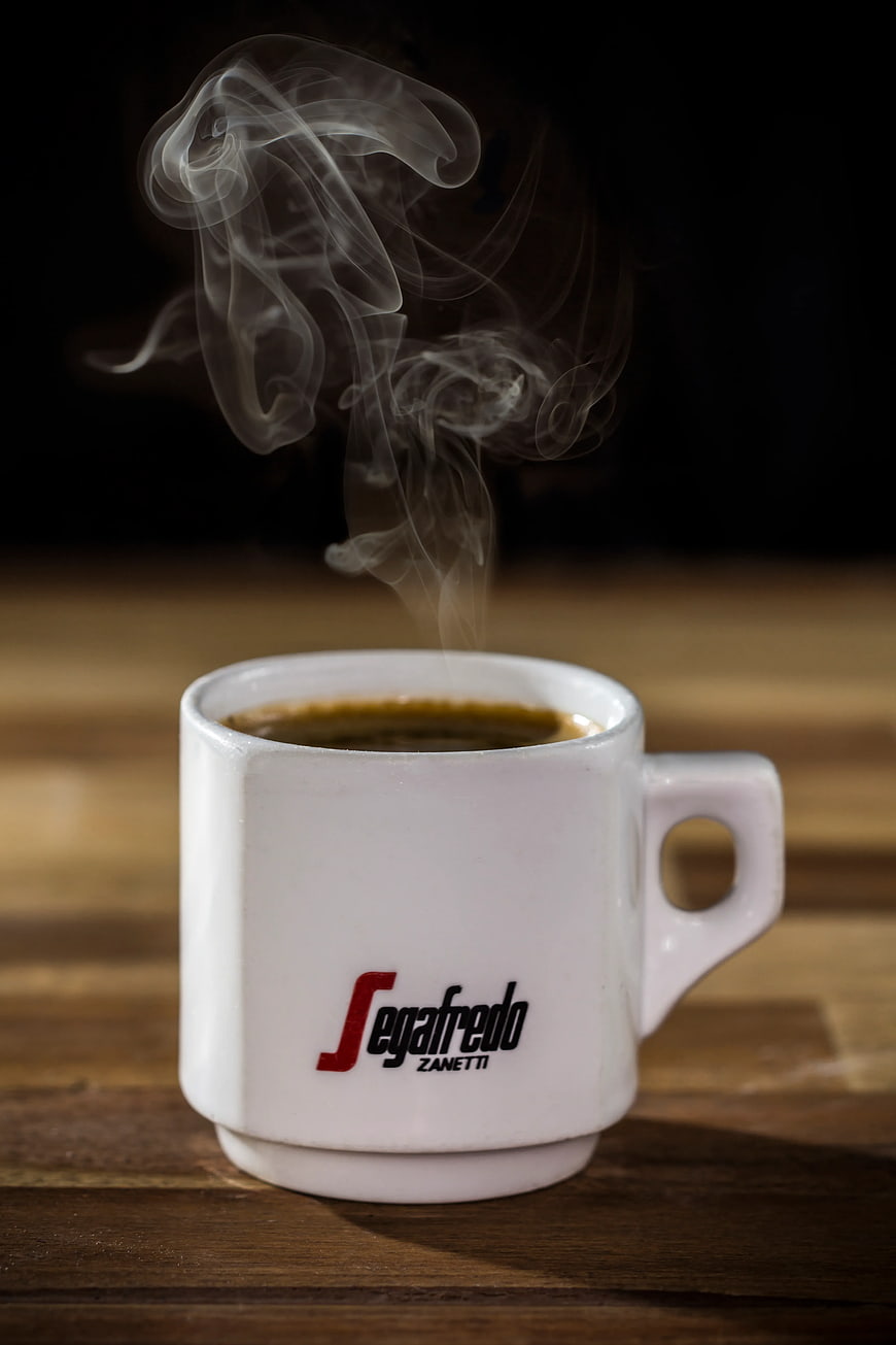 Steaming White Coffee Cup on Wooden Table