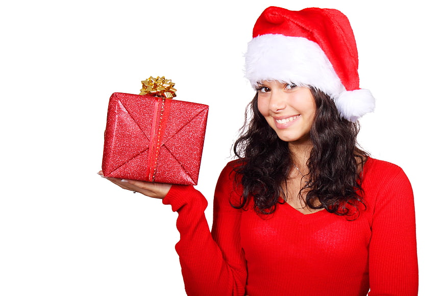 Happy Woman in Santa Hat Holding Red Christmas Gift Box