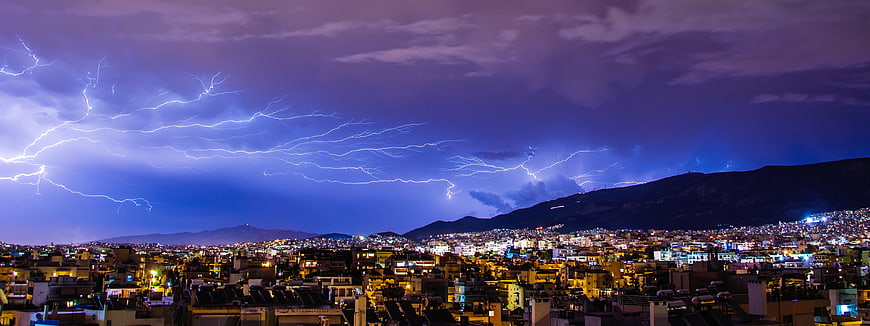 Panoramic Night Cityscape with Dramatic Lightning Storm