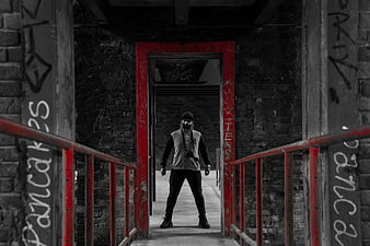 Man in Gas Mask Standing in Red Doorway of Abandoned Building