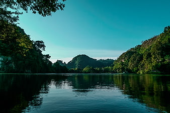 Serene Lake Surrounded by Lush Green Mountains and Trees