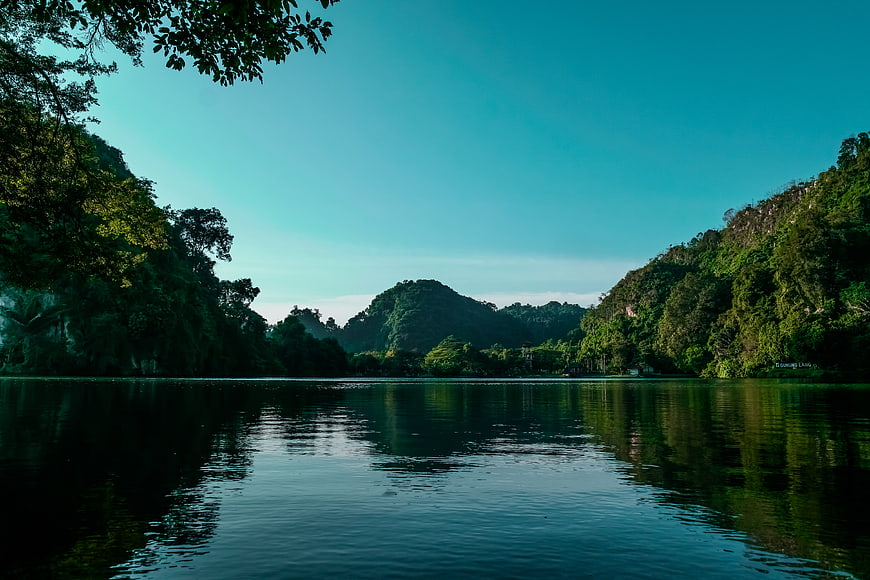 Serene Lake Surrounded by Lush Green Mountains and Trees