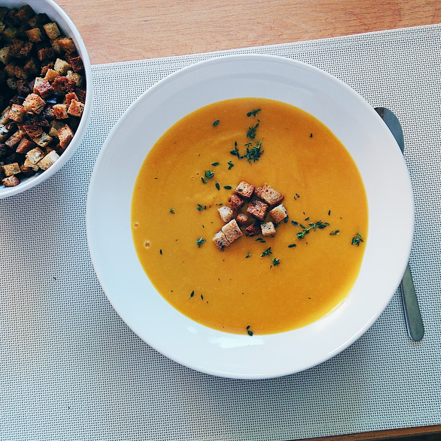 Overhead view of creamy pumpkin soup with croutons