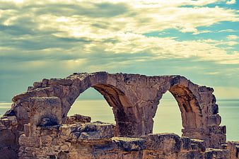 Ancient stone arch ruins overlooking the Mediterranean sea
