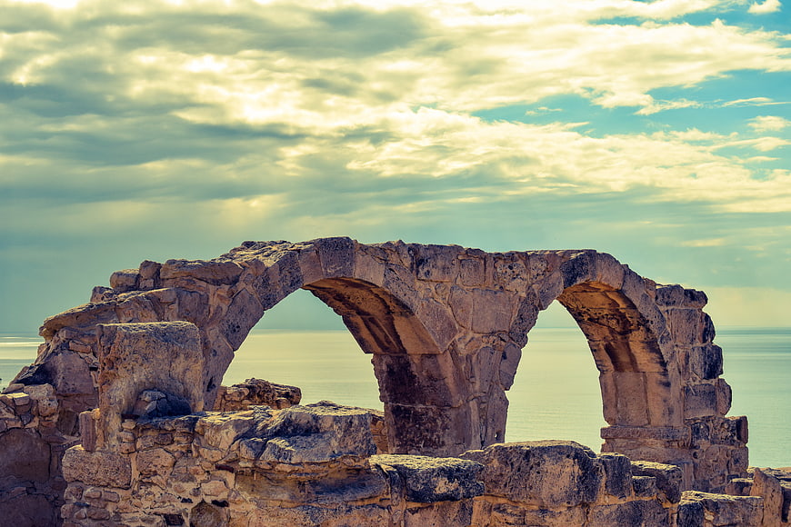 Ancient stone arch ruins overlooking the Mediterranean sea