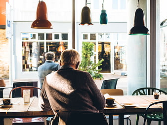 Senior man sitting at cafe table with coffee