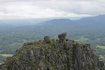 Rugged limestone karst peak overlooking lush green valley