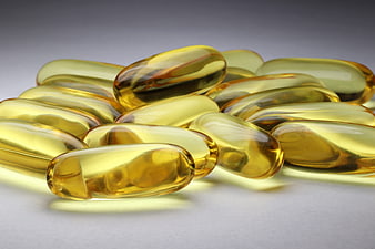 Golden Softgel Capsules on Gray Background