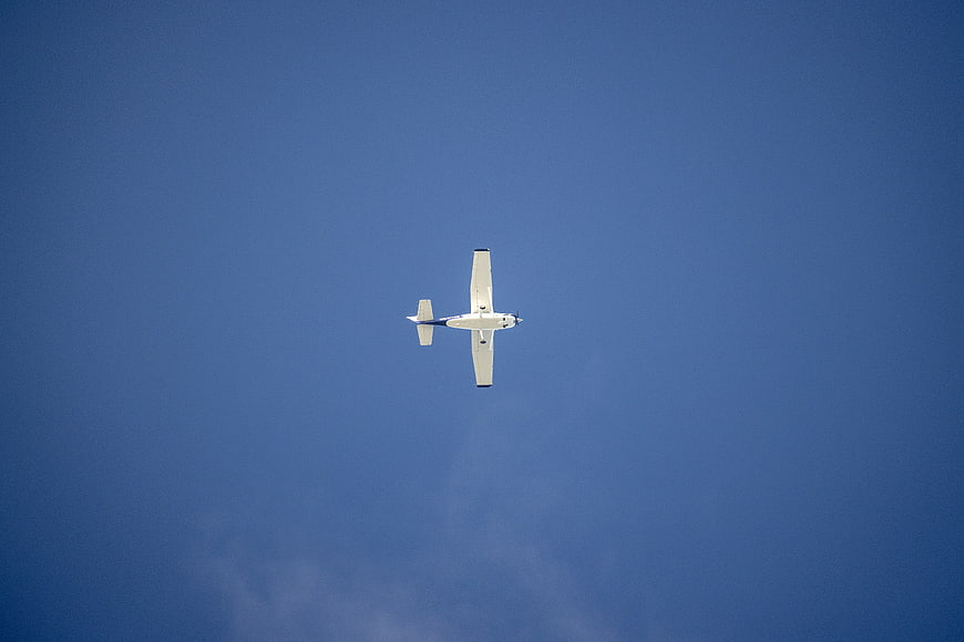 Small Propeller Airplane Flying in Blue Sky