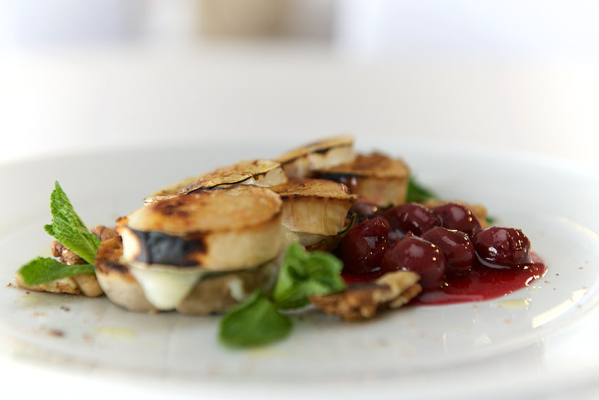 Gourmet Grilled Bananas with Cherries and Mint on White Plate