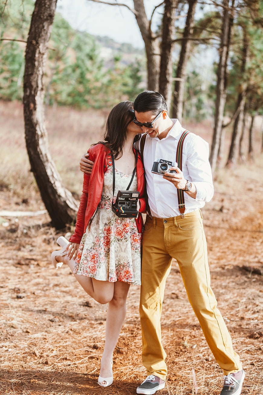 Happy Couple with Vintage Cameras in Pine Forest