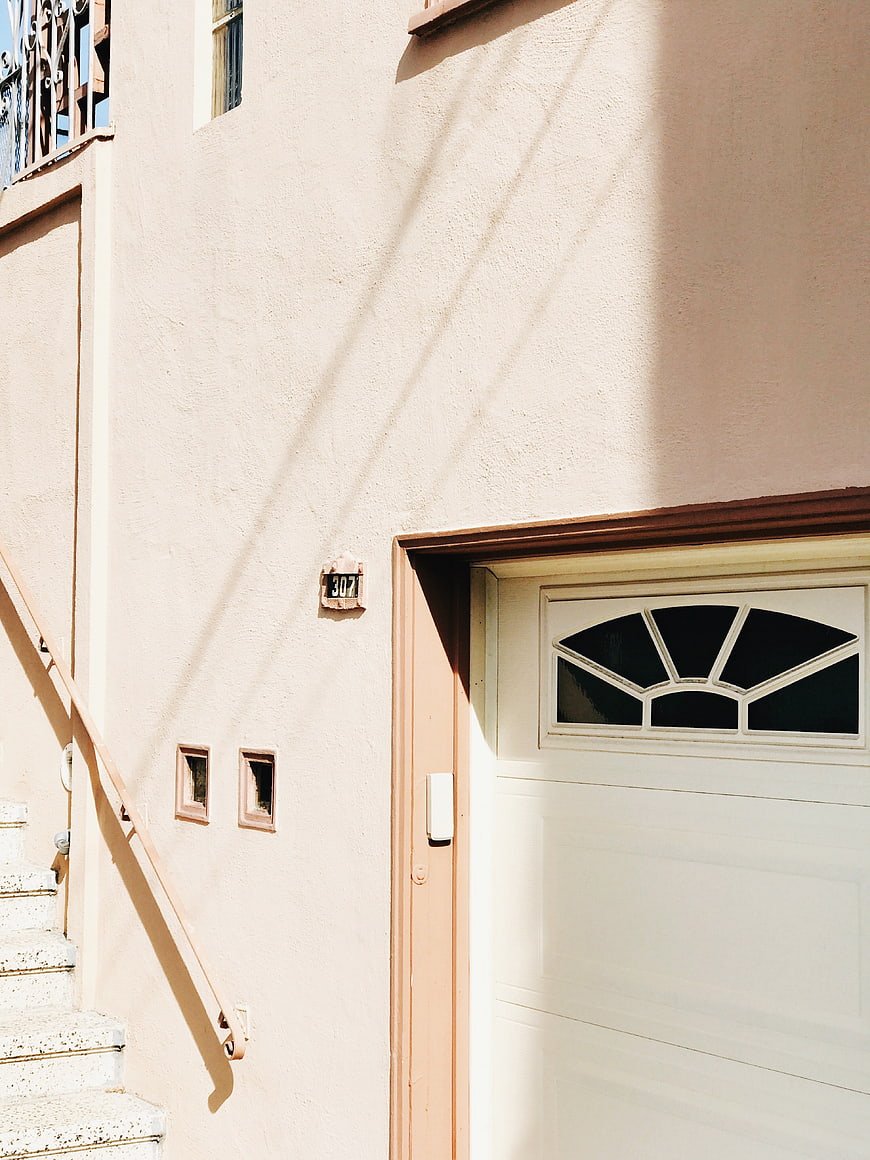Peach Stucco House Exterior with White Garage Door