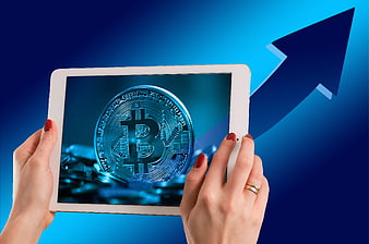 Hands holding tablet with Bitcoin and rising arrow background
