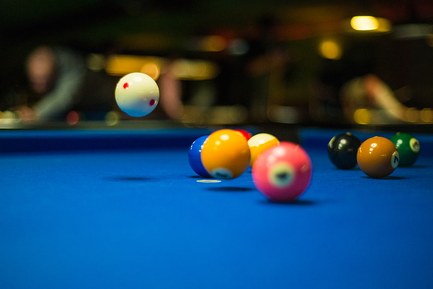 Pool balls in motion on a blue felt table