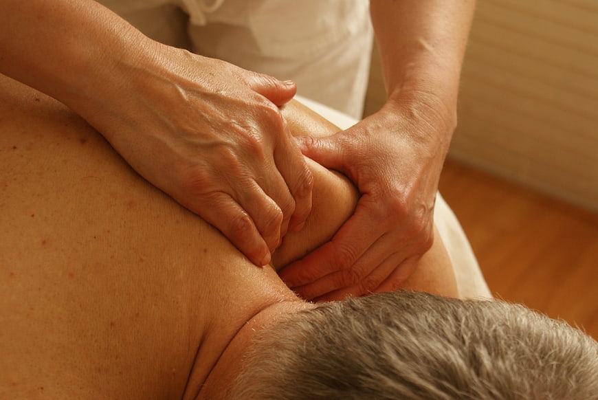 Close-up of hands performing deep tissue shoulder massage