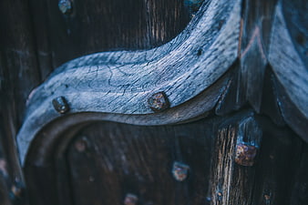 Close-up of weathered carved wood with rusty nails