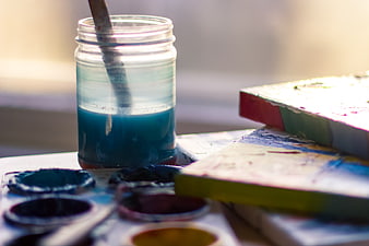 Blue watercolor paint jar and palette on artist table