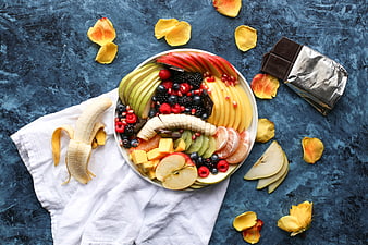 Colorful fruit platter with chocolate on blue background