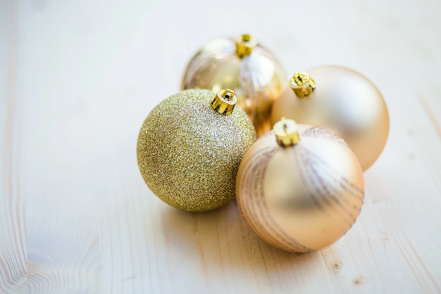 Gold Christmas Baubles on Light Wooden Background