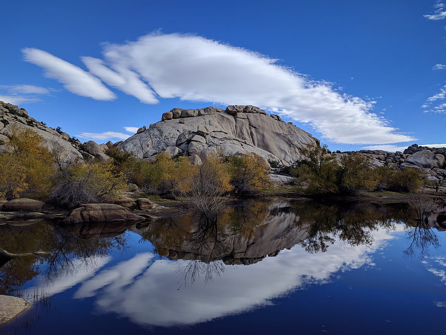 Serene desert landscape with rock formation reflection in water