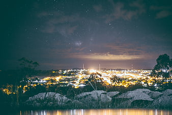 Night Sky Cityscape with Stars and Water Reflection