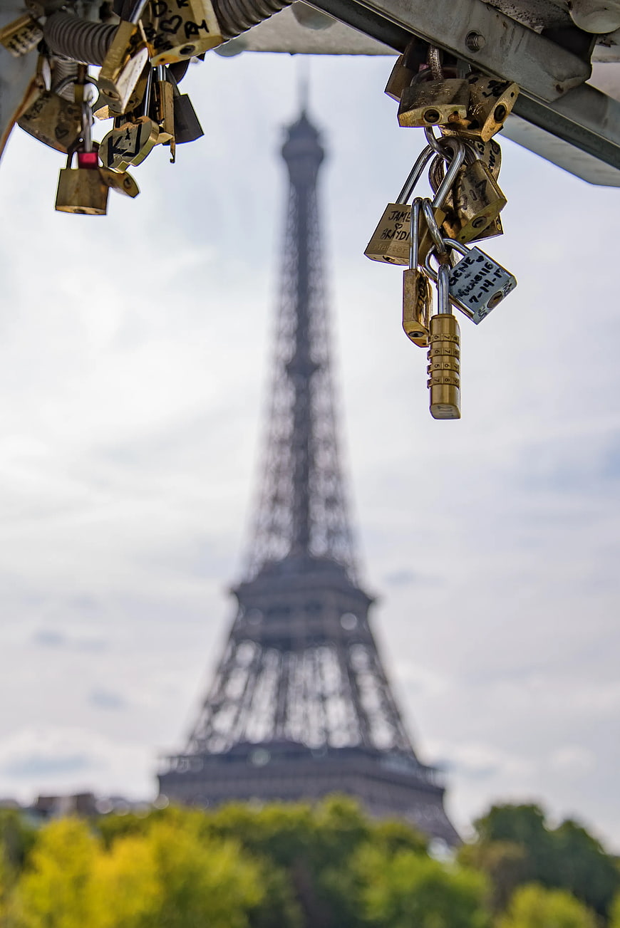 Love padlocks on bridge with Eiffel Tower background