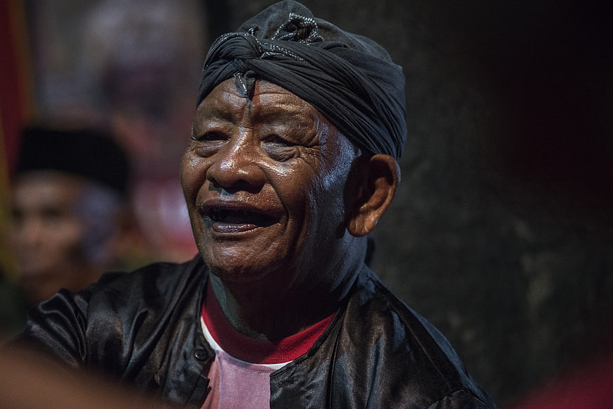 Emotional Portrait of Elderly Indonesian Man Wearing Traditional Turban