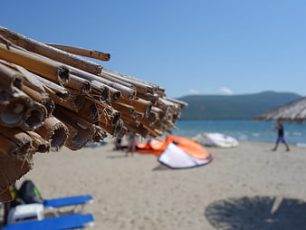 Close-up of bamboo beach umbrella with blurred summer sea background