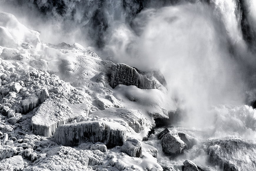 Frozen waterfall with ice formations and misty spray