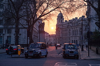 London Black Cabs Driving on Street at Sunset