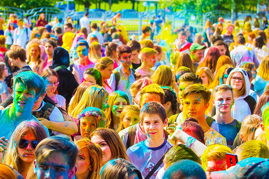 Crowd of young people covered in colorful powder at Holi festival