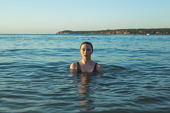 Woman Swimming in Ocean at Sunset