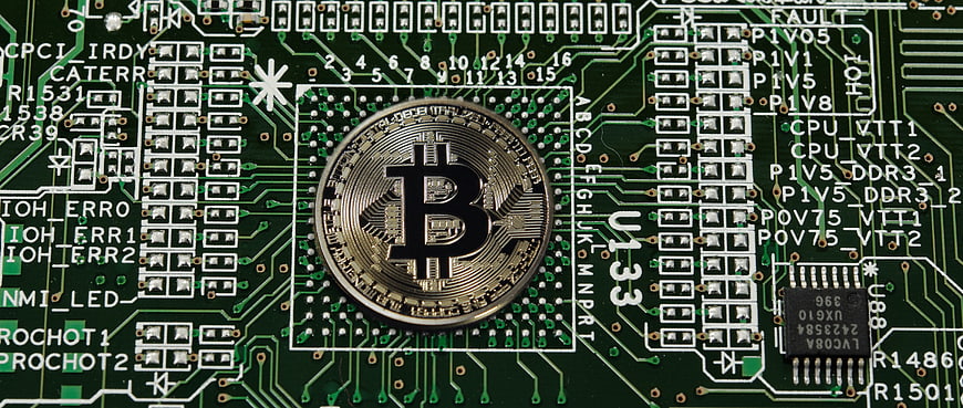 Bitcoin Coin Placed On Green Computer Motherboard Circuit Board
